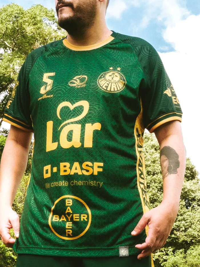 Camisa verde com escudo e patrocinadores na frente