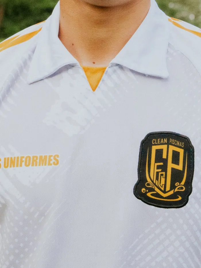 Detalhe da camisa polo branca com escudo da Clean Piscinas